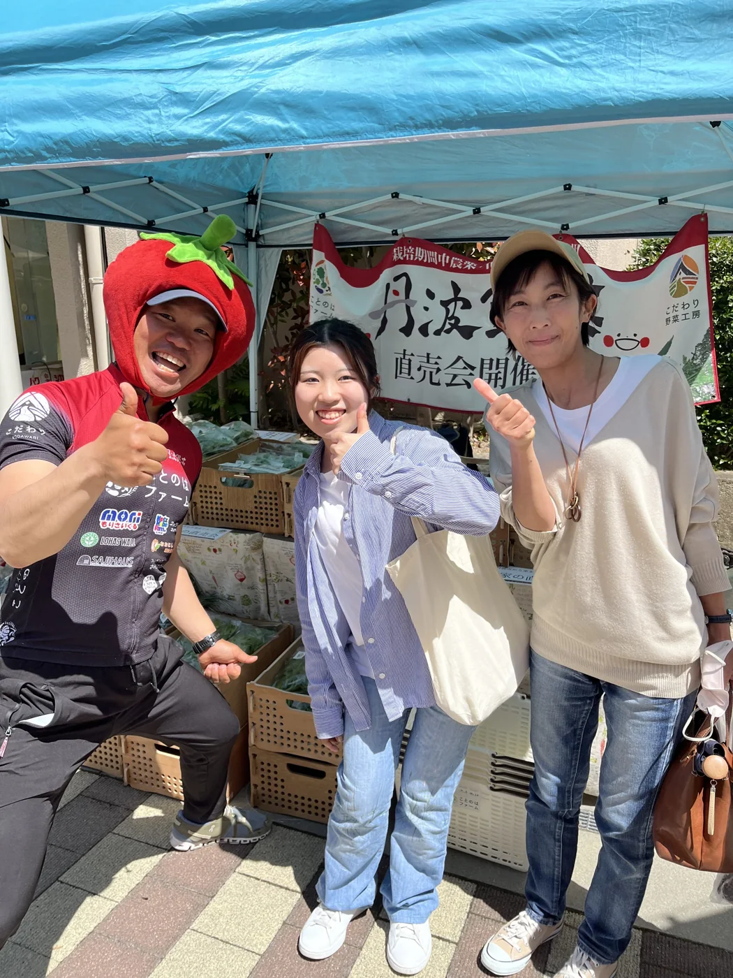 トマトのかぶり物をしたよっしーが、有野台でハルちゃん親子と笑顔で写る一枚